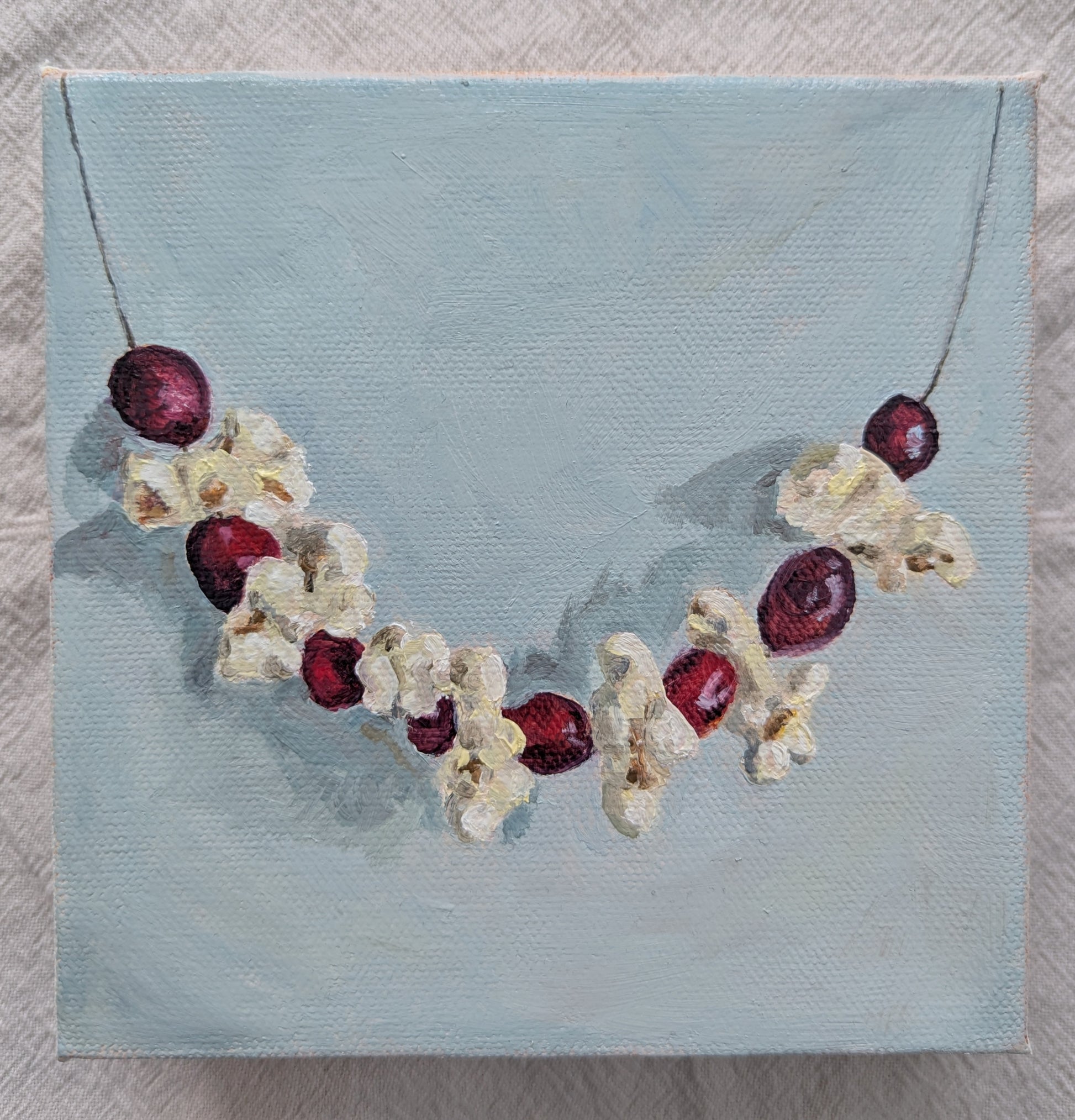 Original oil painting of festive popcorn garland, 6x6 inches on stretched canvas by Emily Langer